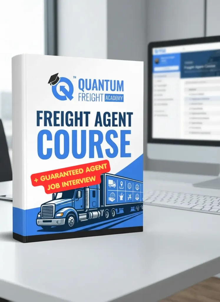 A 3D mockup of a white and blue textbook for the "FREIGHT AGENT COURSE" by Quantum Freight Academy sits on a clean white desk in a bright office. A prominent red banner overlay on the book cover advertises "+ GUARANTEED AGENT JOB INTERVIEW" above an illustration of a blue semi-truck. The background features a soft-focus view of a computer monitor displaying a digital course platform, along with a keyboard and mouse, emphasizing a professional educational setting.